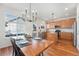 Open-concept dining area with kitchen view, stylish lighting, and a large window at 8381 E 29Th Ave, Denver, CO 80238