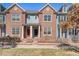 Inviting brick townhome featuring a charming fenced yard and colorful doors at 8381 E 29Th Ave, Denver, CO 80238