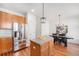 Bright kitchen with stainless steel appliances, wood cabinets, and a charming island at 8381 E 29Th Ave, Denver, CO 80238