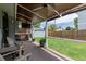 Cozy back patio featuring a ceiling fan, TV, wooden chairs, and a lush green lawn, perfect for relaxing outdoors at 6119 Zenobia Ct, Arvada, CO 80003