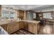Charming kitchen featuring wood cabinets, granite countertops, and stainless steel appliances, seamlessly connected to the dining area at 6119 Zenobia Ct, Arvada, CO 80003