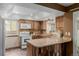 Functional kitchen featuring wood cabinets, stone countertops, and modern appliances at 6119 Zenobia Ct, Arvada, CO 80003