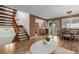 Open-concept living room flowing into dining area with a staircase in view at 6119 Zenobia Ct, Arvada, CO 80003