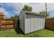 Exterior view of backyard storage shed on lawn, adjacent to wood fence and ladder at 6119 Zenobia Ct, Arvada, CO 80003