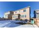 Two-story home with backyard patio, surrounded by snowy landscape at 3912 Trail Stone Cir, Castle Rock, CO 80108