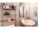 Clean and modern half bathroom with a pedestal sink and decorative shelving at 3912 Trail Stone Cir, Castle Rock, CO 80108