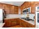 Modern kitchen featuring wood cabinets, quartz countertops, and stainless steel appliances at 3912 Trail Stone Cir, Castle Rock, CO 80108