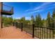 Spacious wood deck with black metal railing overlooking lush green trees at 33606 Gap Rd, Golden, CO 80403