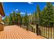 Wood deck with metal railing offers a scenic view of lush forest and nearby hill at 33606 Gap Rd, Golden, CO 80403