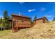Inviting mountain home featuring wood siding, a charming deck, and separate garage at 33606 Gap Rd, Golden, CO 80403