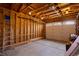 Unfinished garage featuring exposed wood framing, concrete floor and an overhead door at 33606 Gap Rd, Golden, CO 80403