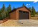 Detached garage with automatic door and siding, complemented by lush trees at 33606 Gap Rd, Golden, CO 80403