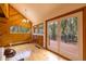 A living room area with hardwood floors, many windows, and an access door to the deck at 33606 Gap Rd, Golden, CO 80403