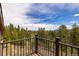 Scenic view from deck with metal railing, overlooking lush treetops and distant mountains at 33606 Gap Rd, Golden, CO 80403