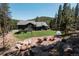 Lush backyard featuring a charming outdoor seating area and well-manicured lawn at 32663 Donna Dr, Conifer, CO 80433
