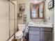 Well-lit bathroom featuring a shower, toilet, vanity, and decorative mirror at 32663 Donna Dr, Conifer, CO 80433