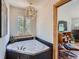 Relaxing bathroom with a jacuzzi tub, and natural light peering through the window at 32663 Donna Dr, Conifer, CO 80433