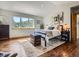 Cozy bedroom with hardwood floors, area rug, large window, and charming decor at 32663 Donna Dr, Conifer, CO 80433