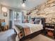Stylish bedroom featuring custom accent wall, plush linens, and cozy décor at 32663 Donna Dr, Conifer, CO 80433