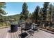Relaxing outdoor deck with comfortable seating, a fire pit, and scenic views at 32663 Donna Dr, Conifer, CO 80433