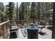 Cozy deck with stylish seating area, fire pit, and view of the surrounding trees at 32663 Donna Dr, Conifer, CO 80433