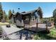 Beautiful two-story home featuring dark gray siding, a spacious deck, and natural landscaping at 32663 Donna Dr, Conifer, CO 80433