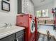 Laundry room featuring side-by-side red washer and dryer units, white countertop, and wood accents at 32663 Donna Dr, Conifer, CO 80433