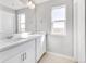 Bright bathroom has double sinks with white cabinets, and a large mirror with modern vanity lighting at 27534 E Byers Ave, Aurora, CO 80018