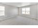 Sunlit room with large windows, neutral walls and carpet creates a serene and inviting space at 27534 E Byers Ave, Aurora, CO 80018
