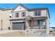 Charming two-story home featuring gray siding, a covered porch, and a two-car garage at 27534 E Byers Ave, Aurora, CO 80018