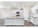 This kitchen showcases stainless appliances, a gray countertop island, and modern white cabinetry at 27534 E Byers Ave, Aurora, CO 80018