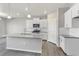 Modern kitchen includes stainless appliances, a gray countertop island, and bright white cabinets at 27534 E Byers Ave, Aurora, CO 80018