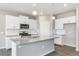 Well-lit kitchen boasts stainless appliances, a gray countertop island, and white cabinets at 27534 E Byers Ave, Aurora, CO 80018