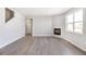 Bright living room features a fireplace, large window, and modern gray flooring at 27534 E Byers Ave, Aurora, CO 80018