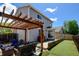 Backyard featuring a pergola, patio seating, artificial grass, and a gray home exterior at 3769 Dahlia St, Denver, CO 80207
