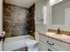 Bathroom with mosaic tile accents, tub, and white vanity with marble countertop at 3769 Dahlia St, Denver, CO 80207