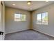 Bedroom featuring two windows offering outdoor views, soft gray carpet, and neutral paint at 3769 Dahlia St, Denver, CO 80207