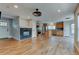 Open-concept living space with hardwood floors, modern fireplace, and seamless flow into the kitchen area at 3769 Dahlia St, Denver, CO 80207