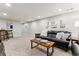Cozy basement space featuring modern light fixtures, carpeted floors, and a comfortable black leather sofa at 794 S Ivy St, Denver, CO 80224