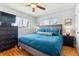 A cozy bedroom featuring a large window, ceiling fan, wood floors, and decor to give this room a peaceful ambience at 794 S Ivy St, Denver, CO 80224