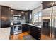Modern kitchen featuring stainless steel appliances, granite countertops, and sleek dark cabinetry at 794 S Ivy St, Denver, CO 80224