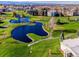 An aerial view of the community golf course, showcasing lush landscaping, mature trees, and water features at 725 S Clinton St # 1B, Denver, CO 80247