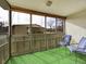 Enclosed balcony with green carpet, cozy seating, and views of surrounding buildings and trees at 725 S Clinton St # 1B, Denver, CO 80247