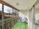 Bright balcony with green carpet, patio chairs, and a view of the community green space and trees at 725 S Clinton St # 1B, Denver, CO 80247
