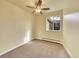 Simple bedroom with neutral carpet, a large window, minimal décor, and a ceiling fan at 725 S Clinton St # 1B, Denver, CO 80247