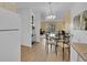 Open dining area with hardwood floors, contemporary lighting, and glass table set near the kitchen and living room at 725 S Clinton St # 1B, Denver, CO 80247