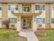 Inviting covered entryway features brick pillars, clear unit signage, and a clean walkway, enhancing curb appeal at 725 S Clinton St # 1B, Denver, CO 80247
