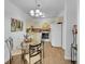 Well-lit kitchen and dining area features bright cabinets, modern appliances, and a stylish chandelier at 725 S Clinton St # 1B, Denver, CO 80247
