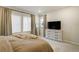 Bright bedroom with light neutral tones, dresser, and large windows at 6950 Hidden Cove Ct, Castle Pines, CO 80108
