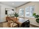 Dining room with a natural wood table, modern art, and large bright window at 6950 Hidden Cove Ct, Castle Pines, CO 80108
